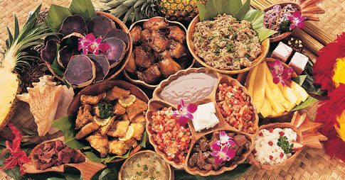 Table of Hawaiian food - pineapple, taro, poi, poke, chicken long rice, lau lau, chicken. Definitely a Hawaiian Luau